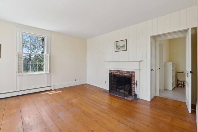 538 Malbons Mills Rd, Skowhegan, ME 04976 - unfurnished living room with a fireplace, light wood finished floors, and a baseboard heating unit