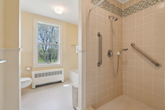 538 Malbons Mills Rd, Skowhegan, ME 04976 - bathroom with radiator, a tile shower, toilet, and tile walls