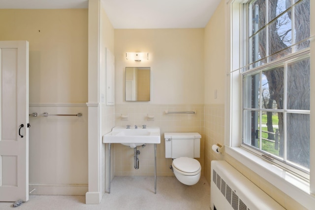 538 Malbons Mills Rd, Skowhegan, ME 04976 - bathroom with radiator heating unit, toilet, wainscoting, and tile walls