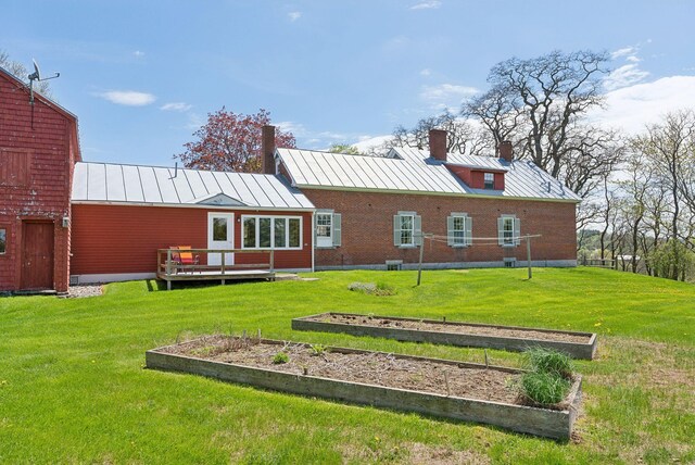 538 Malbons Mills Rd, Skowhegan, ME 04976 - rear view of property featuring a standing seam roof, a vegetable garden, a chimney, metal roof, and a yard