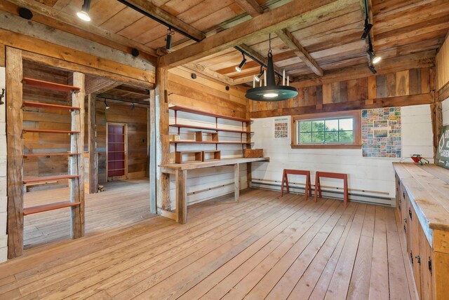 538 Malbons Mills Rd, Skowhegan, ME 04976 - interior space with rail lighting, a baseboard radiator, wood ceiling with exposed beams, wood-type flooring, and wooden walls