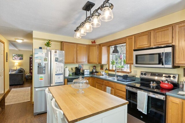 212 New Dam Rd, Waterboro, ME 04061 - kitchen featuring stainless steel appliances, a sink, butcher block counters, and a center island