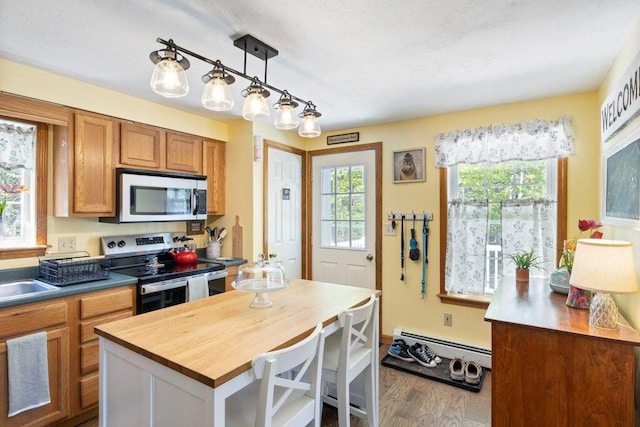 212 New Dam Rd, Waterboro, ME 04061 - kitchen featuring appliances with stainless steel finishes, a baseboard radiator, wooden counters, and healthy amount of natural light