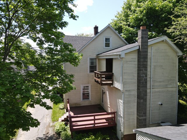 19 Russell St, Bangor, ME 04401 - back of property with a balcony, a chimney, roof with shingles, and a deck