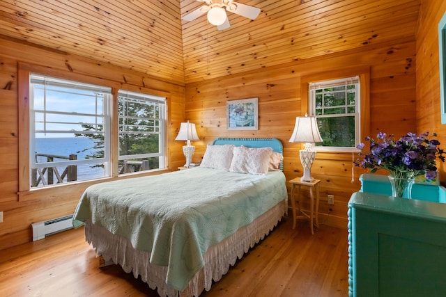 21 Linekin Rd, Boothbay Harbor, ME 04538 - bedroom with a baseboard radiator, wooden walls, multiple windows, and light wood-style flooring