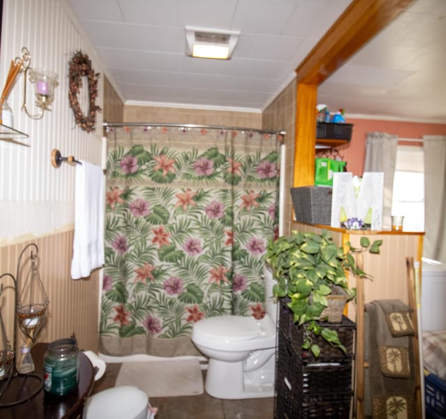 bathroom featuring toilet, curtained shower, ornamental molding, and tile patterned flooring