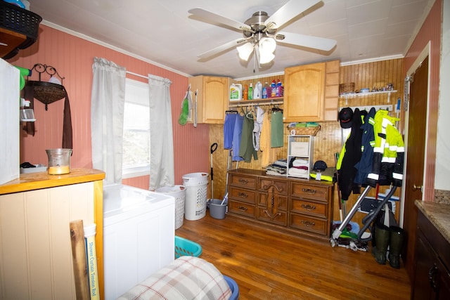 bedroom with crown molding, wood finished floors, and washer / dryer