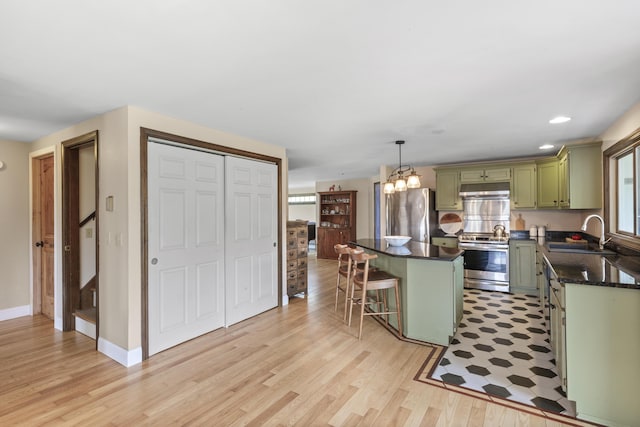 17 Westview Rd, Damariscotta, ME 04543 - kitchen with green cabinetry, appliances with stainless steel finishes, a sink, light wood finished floors, and under cabinet range hood