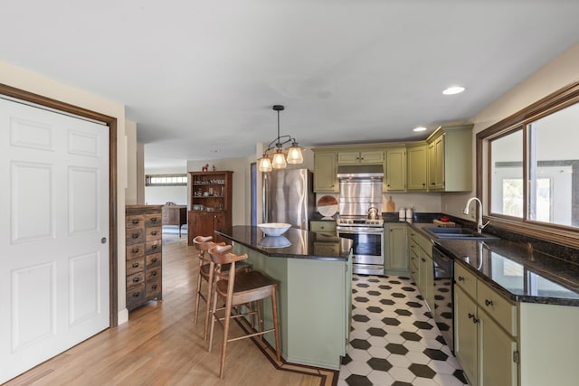17 Westview Rd, Damariscotta, ME 04543 - kitchen featuring green cabinets, a sink, appliances with stainless steel finishes, a breakfast bar, and a center island