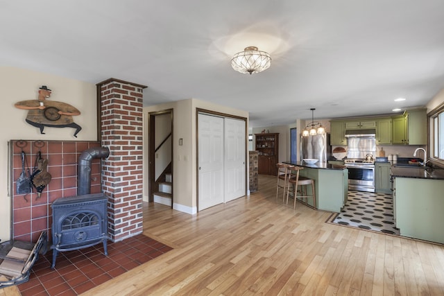 17 Westview Rd, Damariscotta, ME 04543 - kitchen with green cabinets, stainless steel electric stove, dark countertops, a sink, and light wood finished floors