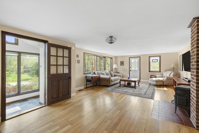 17 Westview Rd, Damariscotta, ME 04543 - living room with a wood stove, light wood-style flooring, and baseboards