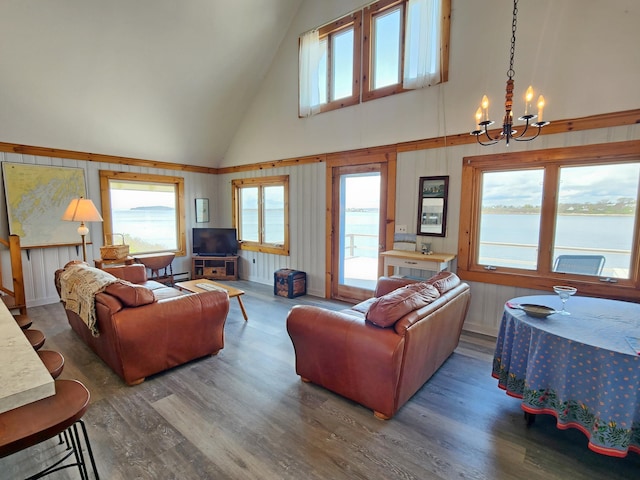 61 W Shore Rd, Harpswell, ME 04079 - living area featuring high vaulted ceiling, a chandelier, wood finished floors, and wood walls