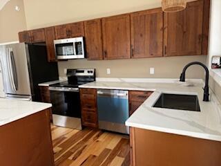 29 Sunnybrook Farm Rd, Bridgton, ME 04009 - kitchen with stainless steel appliances, a sink, light wood-style floors, light countertops, and brown cabinetry