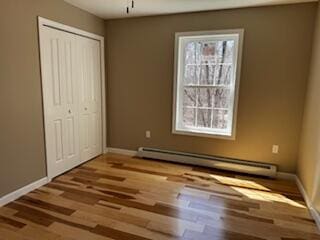 29 Sunnybrook Farm Rd, Bridgton, ME 04009 - unfurnished bedroom featuring baseboard heating, wood finished floors, a closet, and baseboards