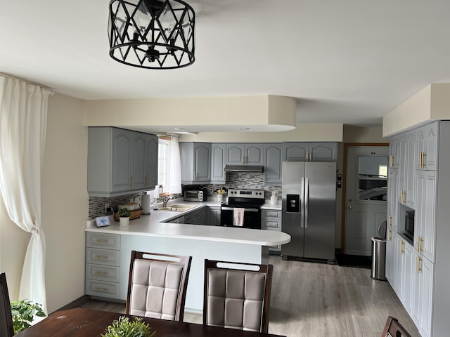 56 Solar Dr, Caribou, ME 04736 - kitchen featuring stainless steel appliances, gray cabinetry, a peninsula, and decorative backsplash