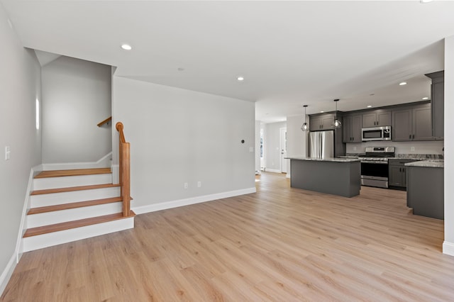 32 Jackson St, Portland, ME 04103 - kitchen featuring stainless steel appliances, a center island, baseboards, light wood finished floors, and recessed lighting