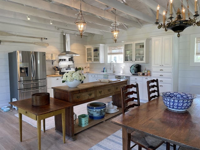 32 Murray Hill Rd, Boothbay, ME 04544 - kitchen with stainless steel fridge with ice dispenser, wall chimney range hood, light wood-style flooring, white cabinetry, and light countertops
