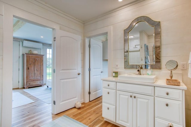 32 Murray Hill Rd, Boothbay, ME 04544 - bathroom with wood finished floors, vanity, an AC wall unit, and ornamental molding