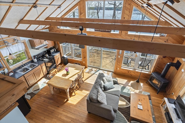 33 Bernier Ln, Harpswell, ME 04079 - living area with a wood stove, hardwood / wood-style flooring, high vaulted ceiling, and healthy amount of natural light