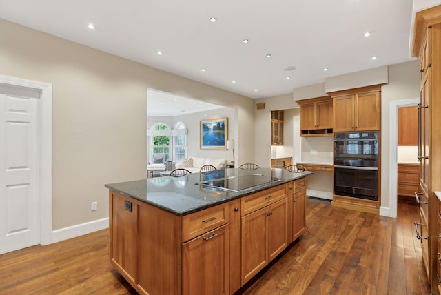 11 Clubhouse Dr, Kennebunk, ME 04043 - kitchen featuring black appliances, a kitchen island, dark wood-style floors, brown cabinets, and dark stone countertops