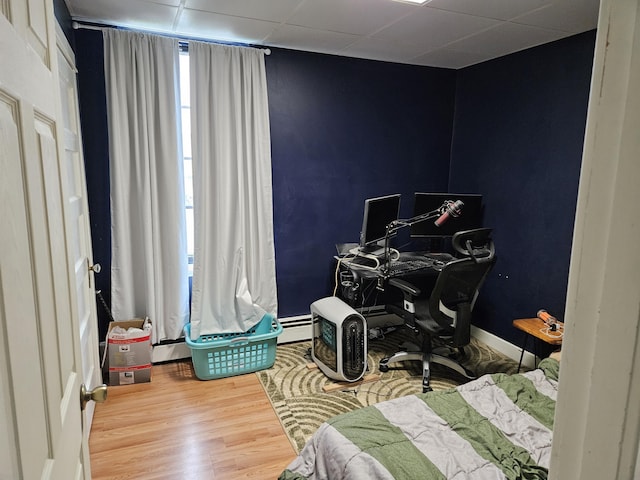 58 Cedar St, Bangor, ME 04401 - bedroom with wood finished floors, a desk, baseboards, and a baseboard heating unit