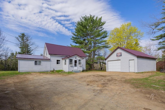 283 School St, Weld, ME 04285 - view of front of home featuring a garage, an outbuilding, driveway, and metal roof
