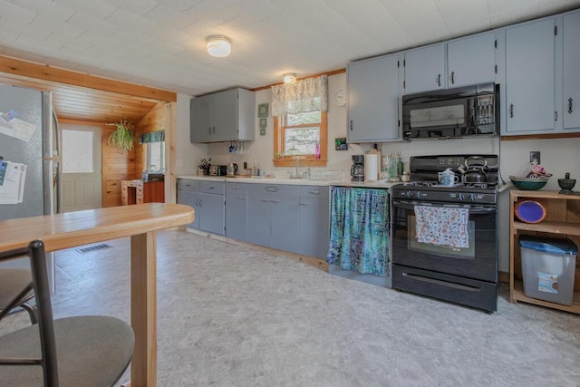 283 School St, Weld, ME 04285 - kitchen with black appliances, gray cabinetry, light countertops, and a sink
