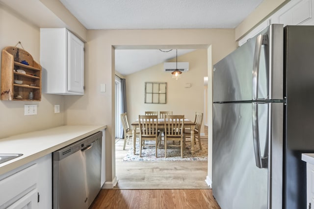 4 Oakview Dr Unit 4, Cape Elizabeth, ME 04107 - kitchen featuring appliances with stainless steel finishes, white cabinetry, light wood finished floors, a wall mounted AC, and lofted ceiling