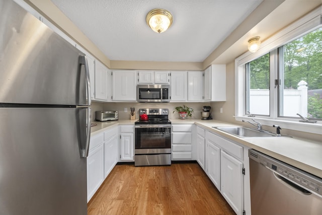 4 Oakview Dr Unit 4, Cape Elizabeth, ME 04107 - kitchen featuring appliances with stainless steel finishes, a sink, wood finished floors, light countertops, and a textured ceiling