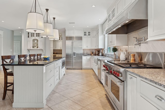 10 Jameson Dr, Falmouth, ME 04105 - kitchen with built in appliances, under cabinet range hood, a breakfast bar, a sink, and backsplash