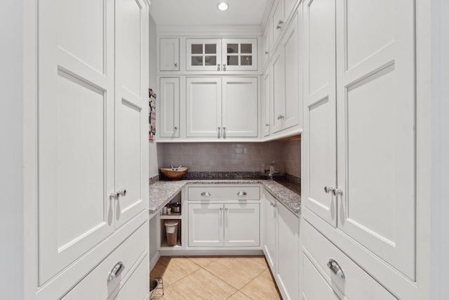 10 Jameson Dr, Falmouth, ME 04105 - kitchen with light tile patterned floors, white cabinetry, backsplash, stone countertops, and glass insert cabinets
