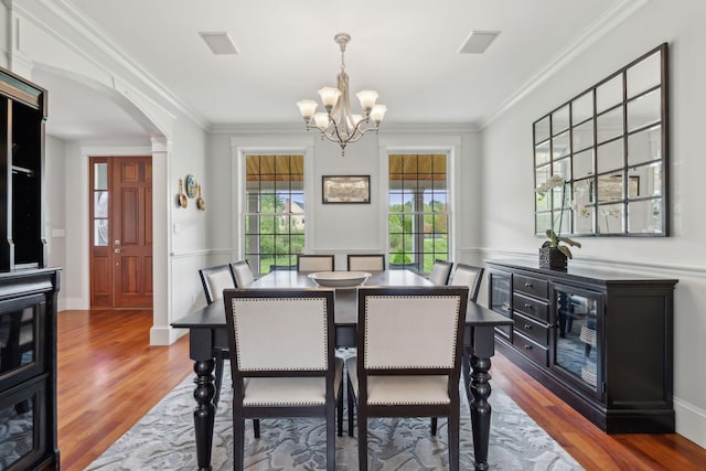 10 Jameson Dr, Falmouth, ME 04105 - dining area featuring arched walkways, a chandelier, wood finished floors, and ornamental molding
