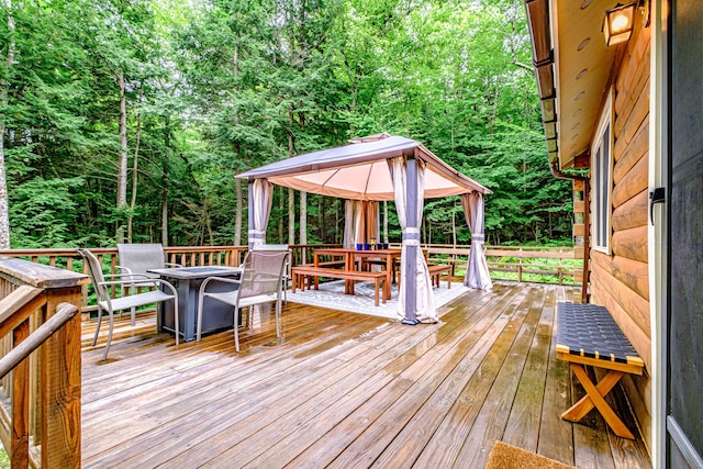 134 Valhalla Ln, Norway, ME 04268 - deck featuring a gazebo, outdoor dining area, and a wooded view
