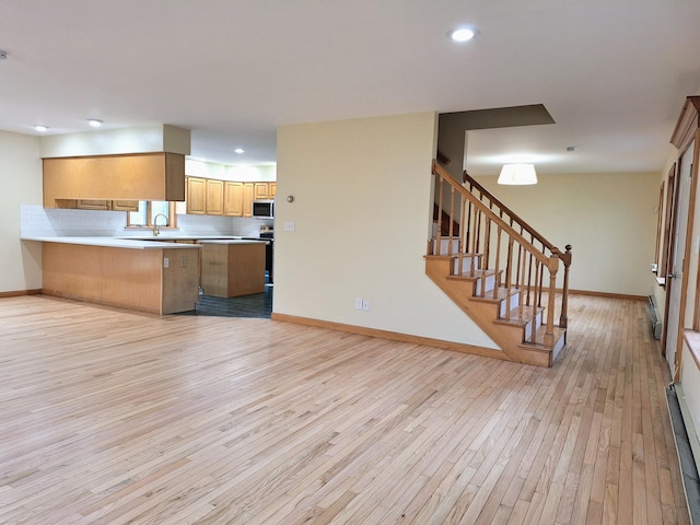 20 Brandywine Cir, Auburn, ME 04210 - kitchen with stainless steel microwave, light wood finished floors, baseboards, open floor plan, and light countertops