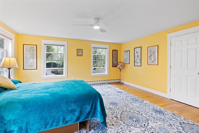 22 Lindas Way, Manchester, ME 04351 - bedroom featuring light wood-type flooring, baseboard heating, baseboards, and a ceiling fan