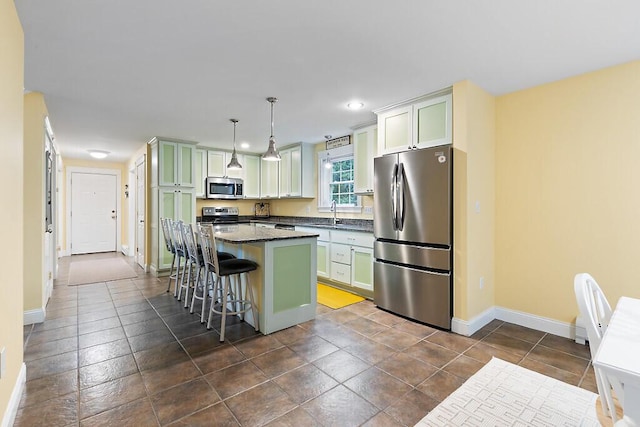 22 Lindas Way, Manchester, ME 04351 - kitchen with stainless steel appliances, baseboards, a kitchen bar, a center island, and a sink