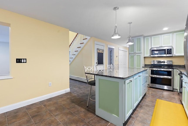 22 Lindas Way, Manchester, ME 04351 - kitchen with stainless steel appliances, a baseboard radiator, a breakfast bar area, dark stone counters, and a kitchen island
