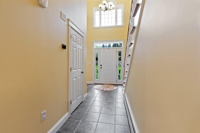 22 Lindas Way, Manchester, ME 04351 - foyer with a chandelier, a high ceiling, baseboards, dark tile patterned floors, and baseboard heating