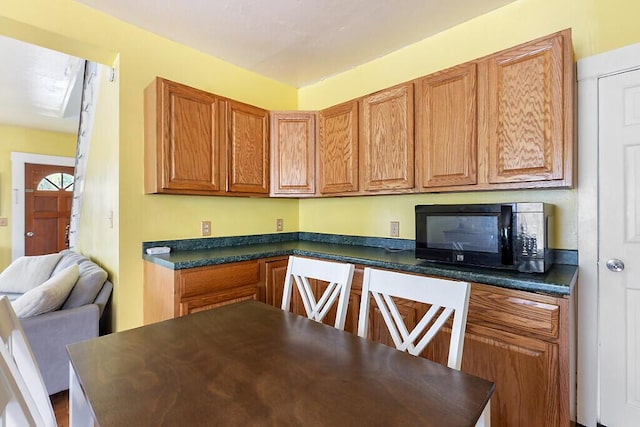 66 Beechwood St, Thomaston, ME 04861 - kitchen featuring black microwave, dark countertops, and brown cabinets