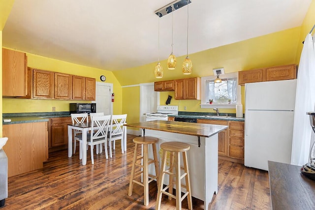 66 Beechwood St, Thomaston, ME 04861 - kitchen with white appliances, dark wood-style floors, a kitchen bar, a sink, and a kitchen island