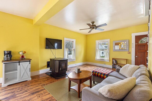 66 Beechwood St, Thomaston, ME 04861 - living room featuring a wood stove, wood finished floors, baseboards, and ceiling fan