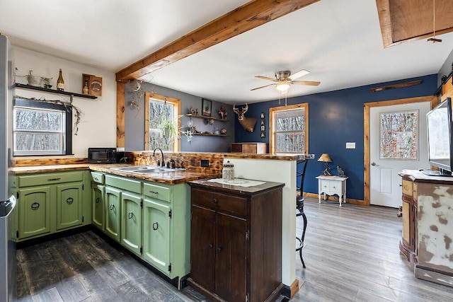 194 Birch Ln, Unity, ME 04988 - kitchen featuring a peninsula, a sink, green cabinetry, dark wood-type flooring, and beam ceiling