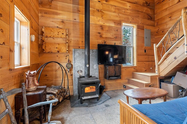 194 Birch Ln, Unity, ME 04988 - living area featuring wood walls, stairs, a wood stove, concrete floors, and electric panel
