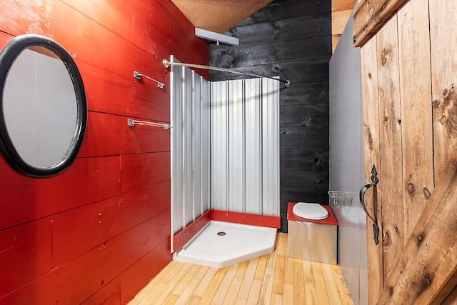 194 Birch Ln, Unity, ME 04988 - bathroom featuring a stall shower, wood walls, and wood finished floors
