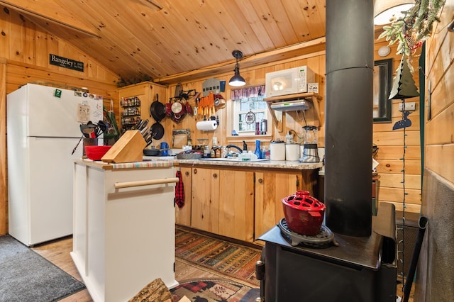 27 Summer Rd, Rangeley, ME 04970 - kitchen with freestanding refrigerator, lofted ceiling, a sink, light wood finished floors, and wood walls