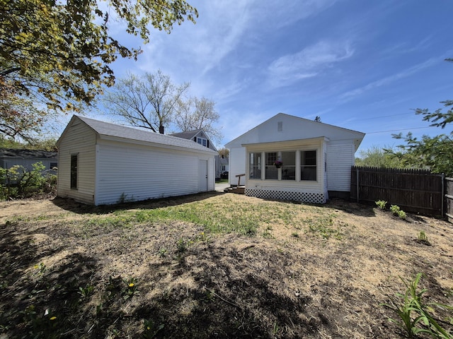 back of house with fence and an outbuilding