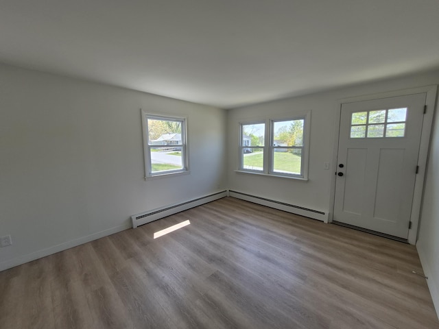 entryway featuring baseboard heating, plenty of natural light, and wood finished floors