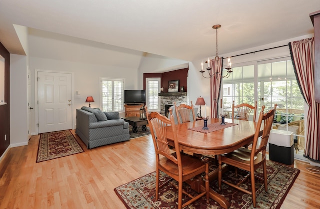 28 Winchester Ct Unit 36, Kennebunk, ME 04043 - dining area featuring light wood-style floors, a fireplace, and a chandelier