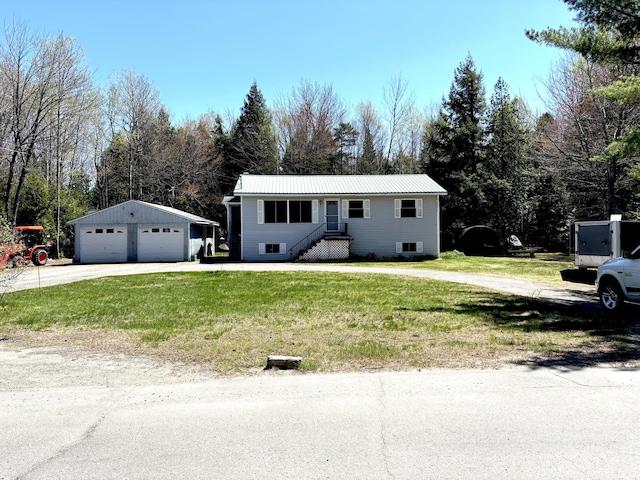 3 Rush Blvd, Millinocket, ME 04462 - view of front facade featuring a garage, an outbuilding, a front lawn, metal roof, and view of wooded area