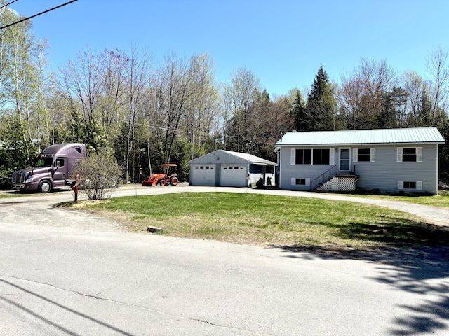 3 Rush Blvd, Millinocket, ME 04462 - view of front facade featuring a garage, a front lawn, metal roof, an outbuilding, and driveway